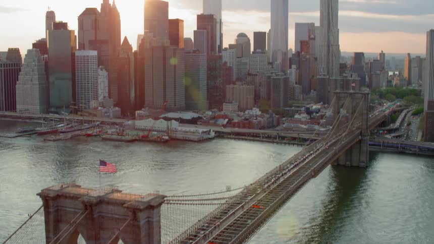 Cars drive over a bridge to a metropolitan area in the morning