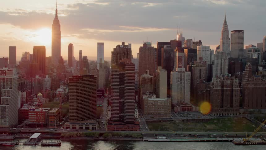 A large urban area with tall buildings sits on a shoreline