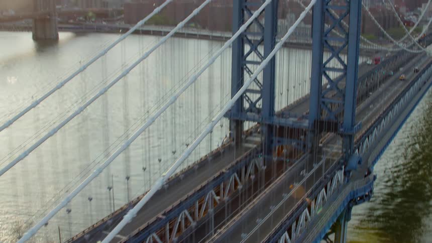 A suspension bridge with a city skyline in the distance
