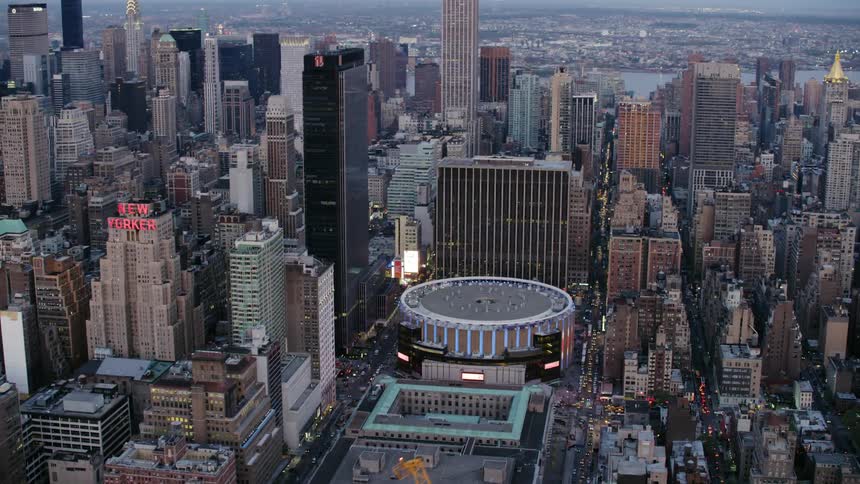 An arena sits in the downtown of a large urban city