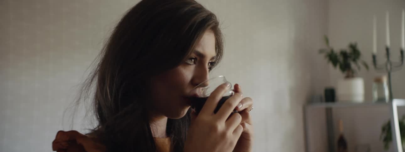 Woman sips beverage from glass
