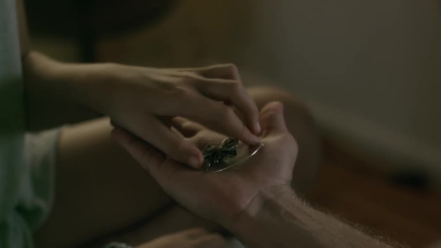 A man hands an object to a woman in a room