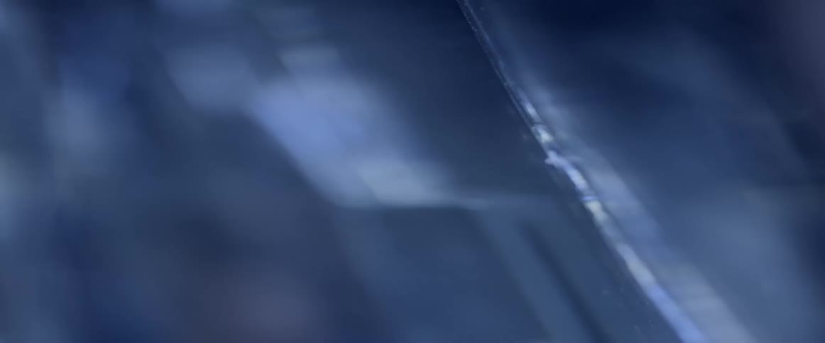Light reflects on cut glass edges with a bluish tint