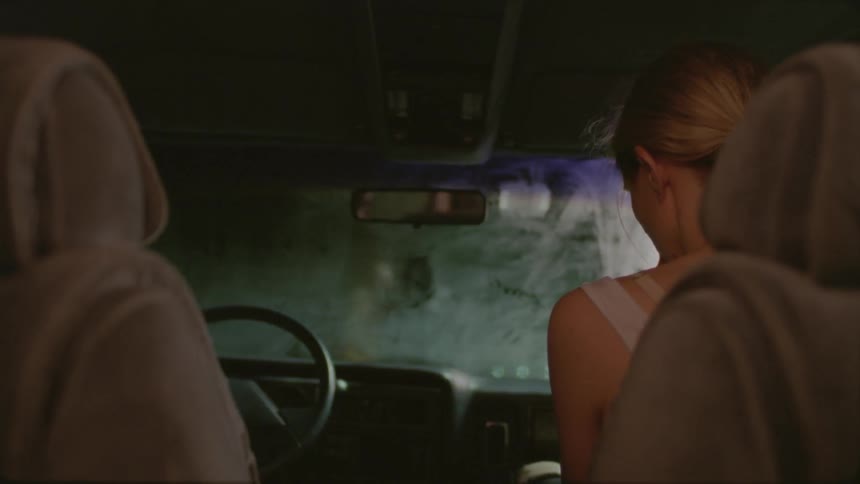 A woman sits in her car