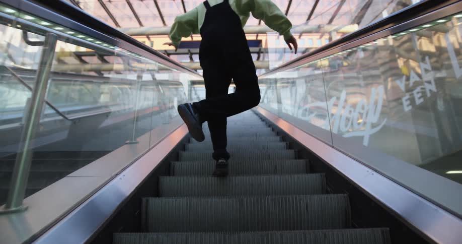 Man dances while taking the escalator up
