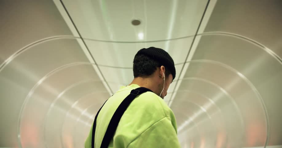 A man is listening to music as he travels through a tunnel