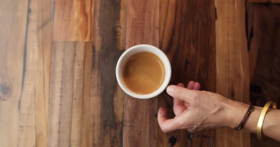 A person places a coffee on the table