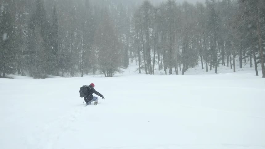 A person climbs through the high snow during a blizzard