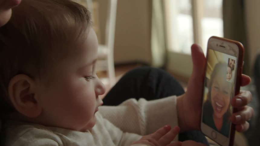 A woman and a baby video chatting on a smart phone