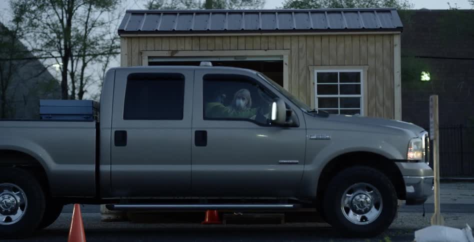 Couple talking inside pickup truck at dusk