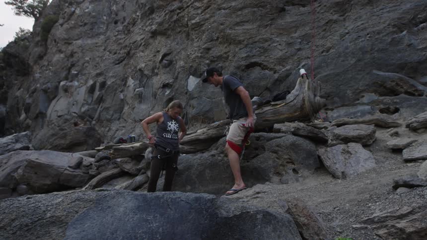 A man and woman put on their climbing gear