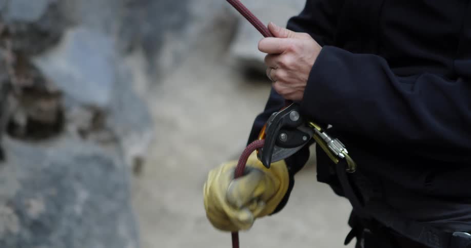 A woman is wearing rock climbing equipment