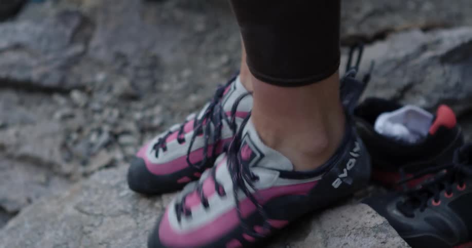 A person puts on their shoes and walks away