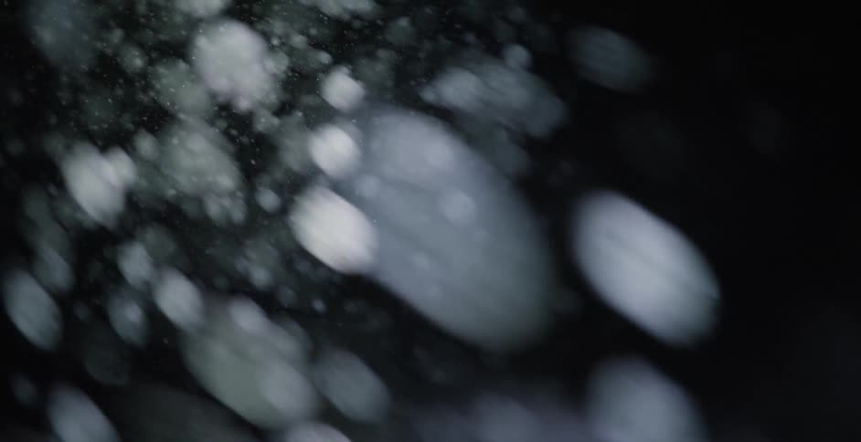 Ethereal snowflakes falling at night
