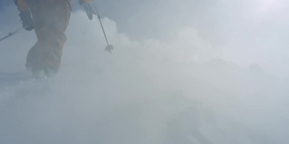 A person climbs a snowy mountain in a wind storm