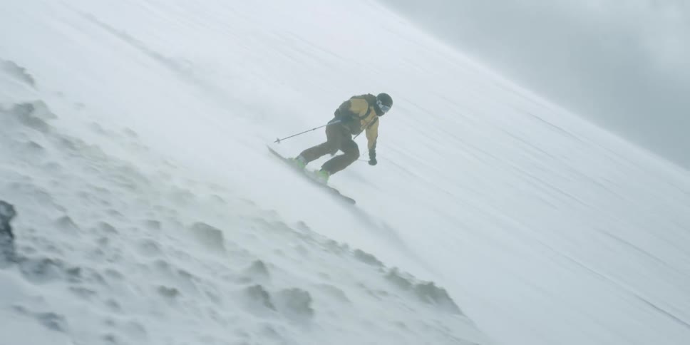 A skier flies by through through a wind storm