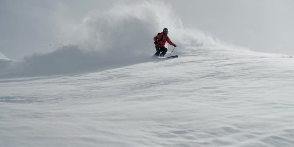A skier sprays powder as they turn past the camera