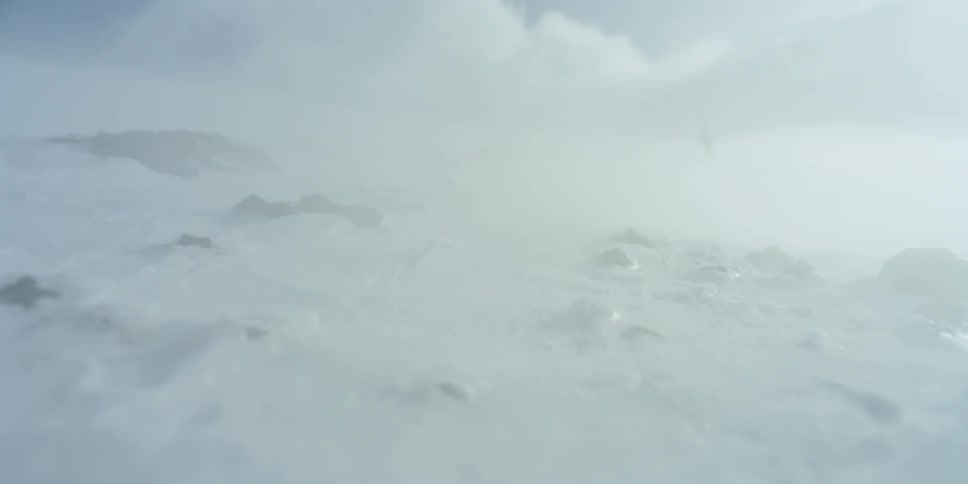 A person climbs up through a snow storm