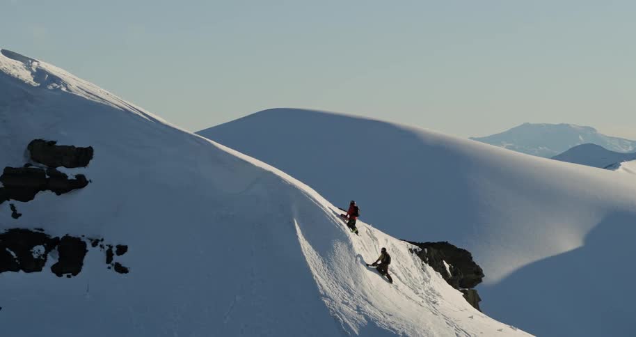 Aerial as two skiers climb an icy mountain