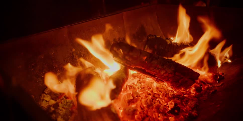 A fire burns brightly in a fireplace