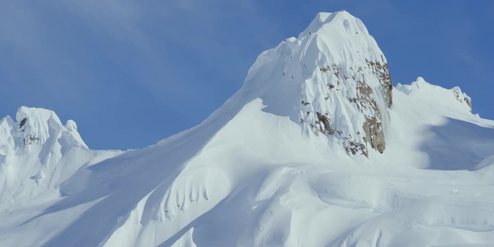 A skier above a steep mountain cliff