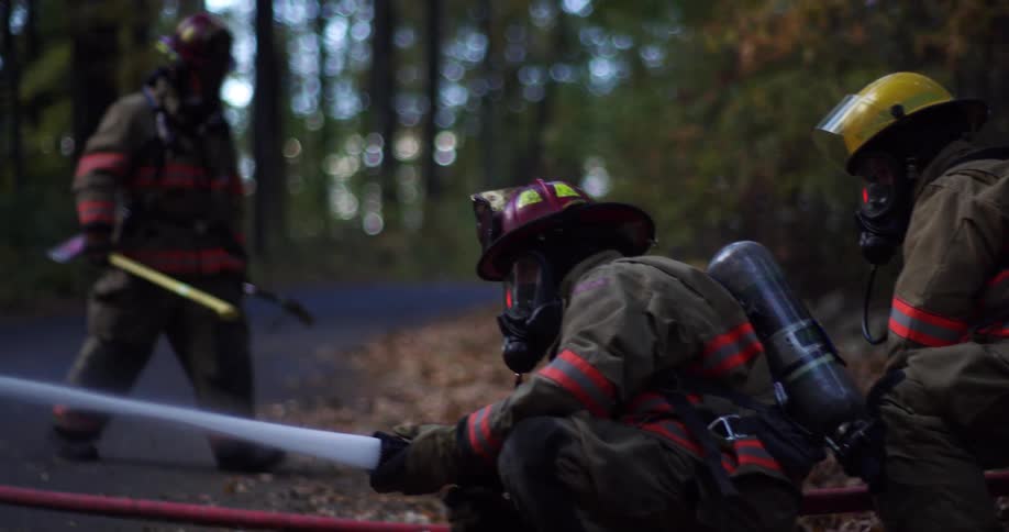 Firefighters spraying fire hose