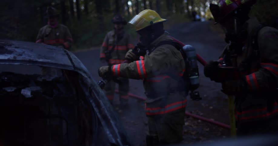 Firefighters work to put a fire in a car out