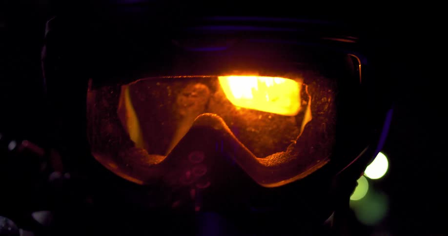 Intermittent light through the goggles of a helmet at night