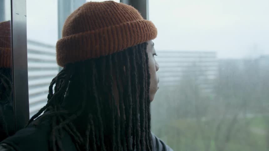Black young men riding elevator with glass windows