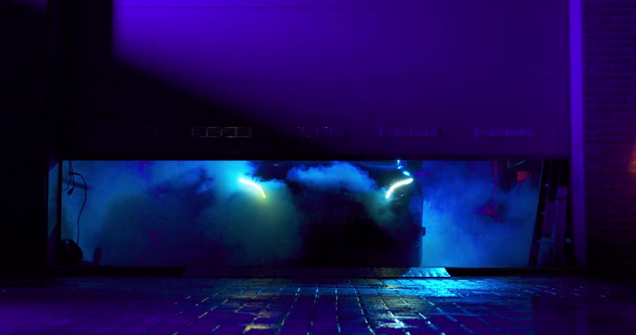 A door opens revealing a futuristic car wreathed in exhaust smoke