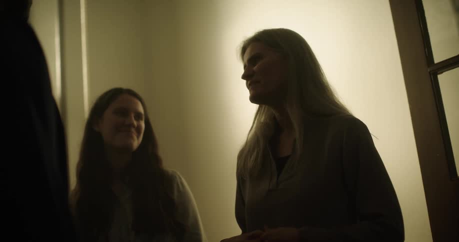 Three people stand and talk with one another