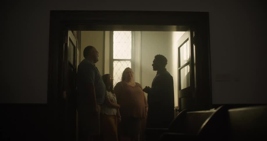 A group of people stand inside and talk