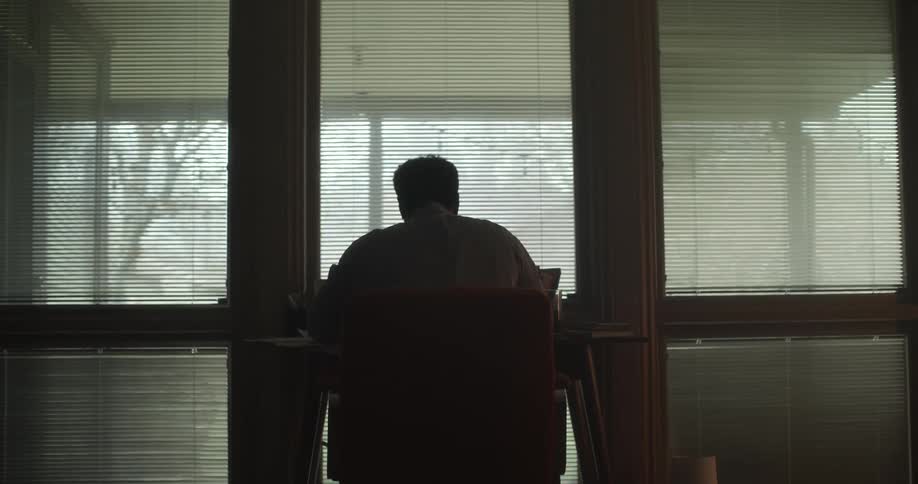 A man sits down at a desk