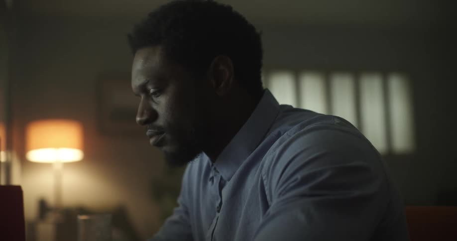 A man sitting down in a room typing