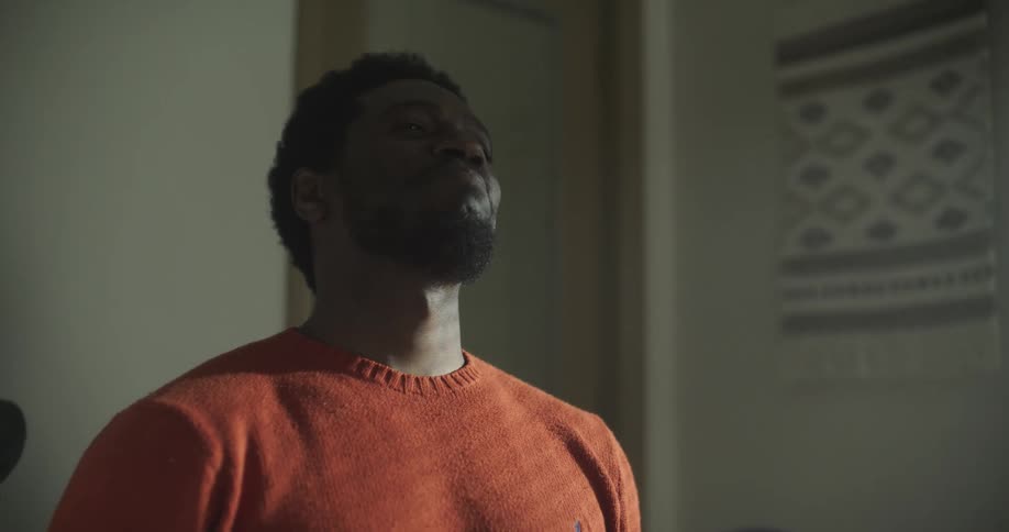 A man looks at a piece of clothing and laughs and claps