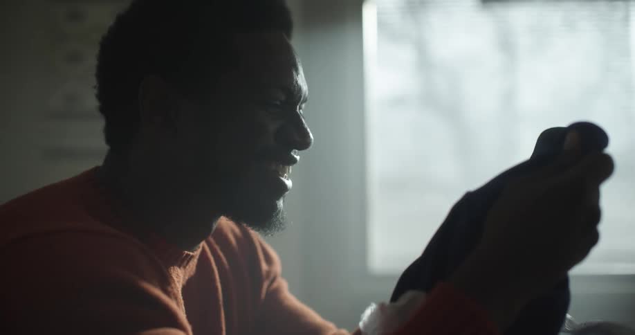 A man is smiling and laughing indoors
