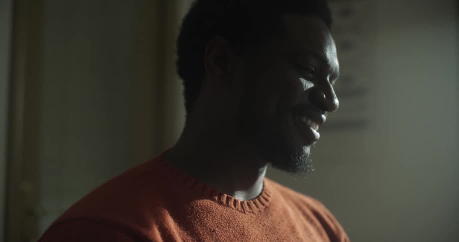A man inside a room laughs