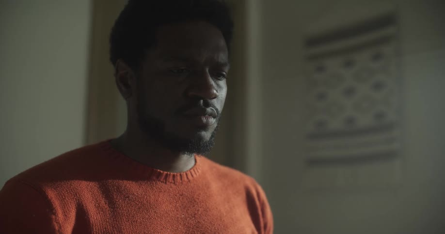 A black man folds over an object