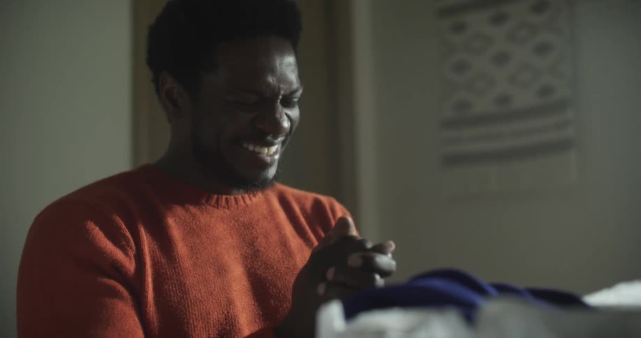 The man smiles with closed hands