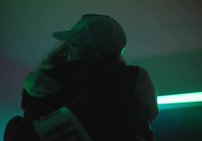 Couple of friends greet each other with a hugh in a party