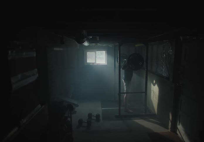 A man picking up weights and doing squats