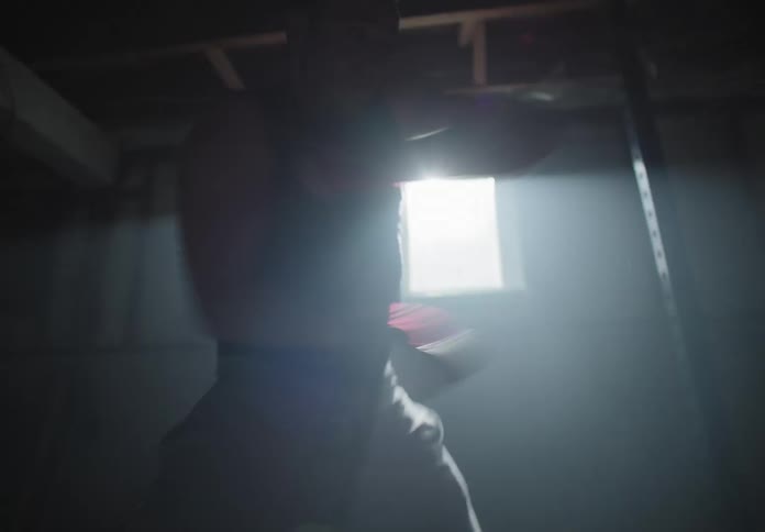 A man in a basement shadowboxing