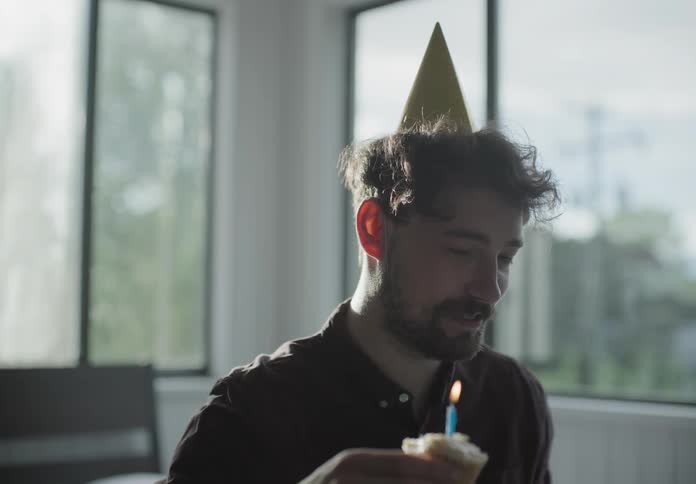 Man on video call in laptop celebrates birthday alone