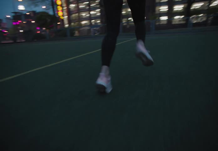 A young woman runs sprints on an athletic field