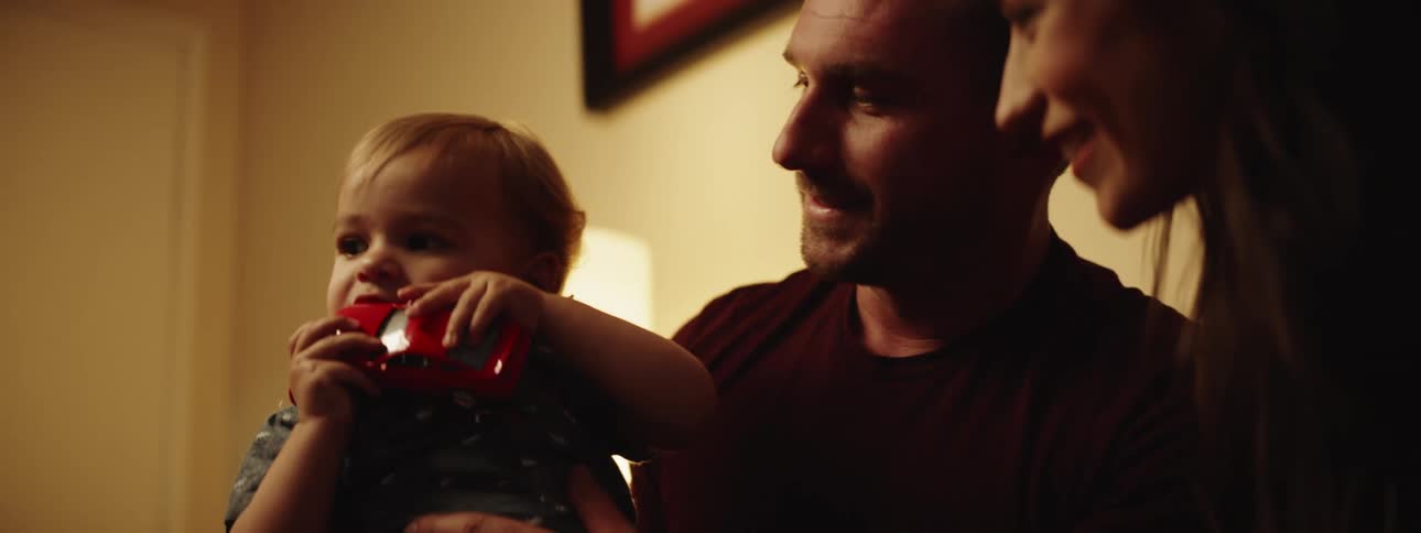 A man and woman playing with a child sitting on the mans lap