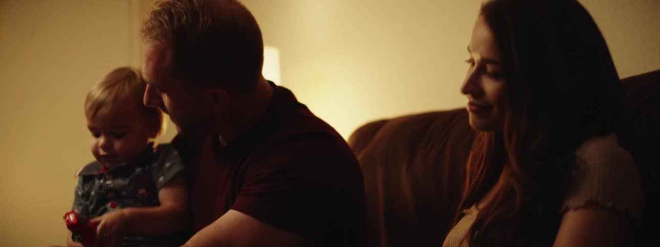 A family is sitting on a couch indoors