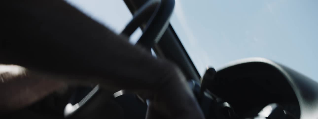 Man steers and shift car on clear day