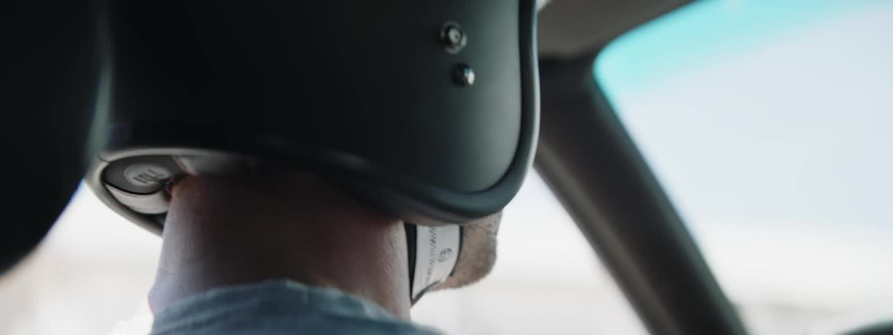 A man wearing a helmet is driving a vehicle