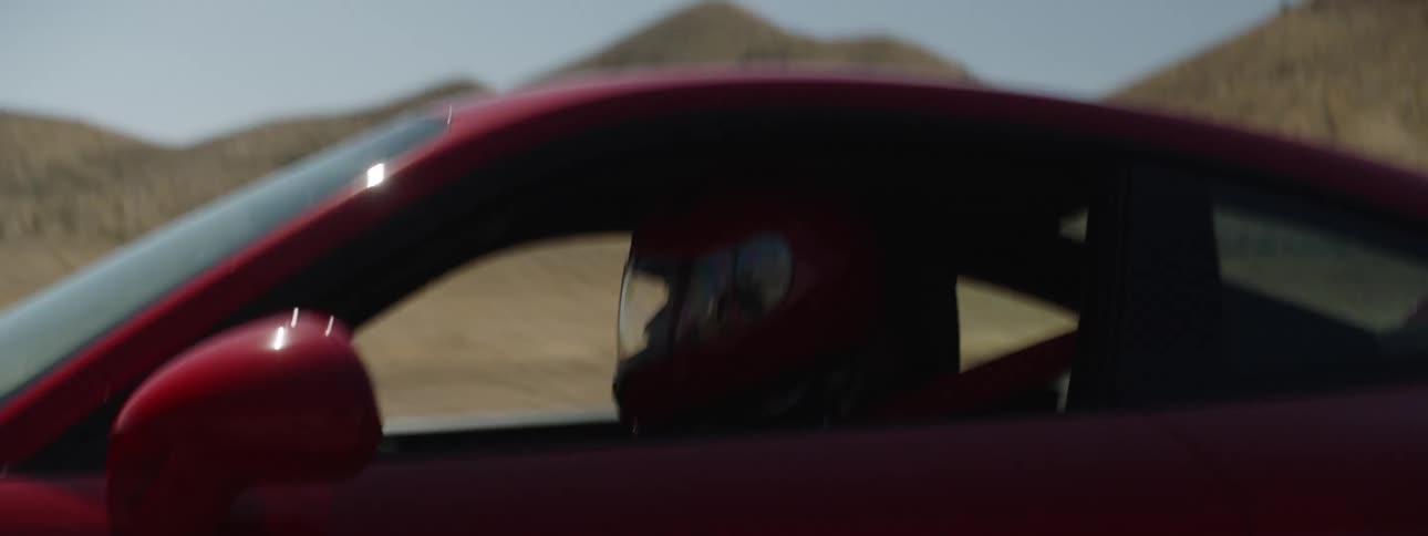 A man is driving a racecar outdoors