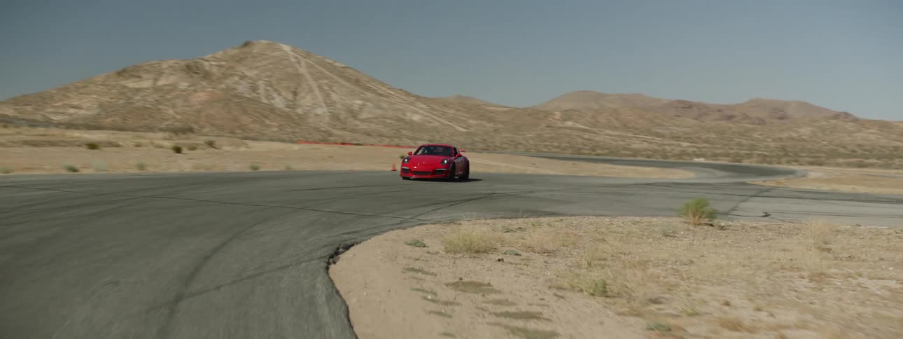 A car is driving in a desert area